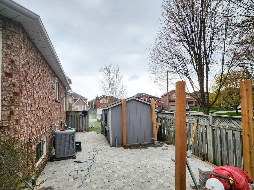 A man is working on a patio in front of a house.