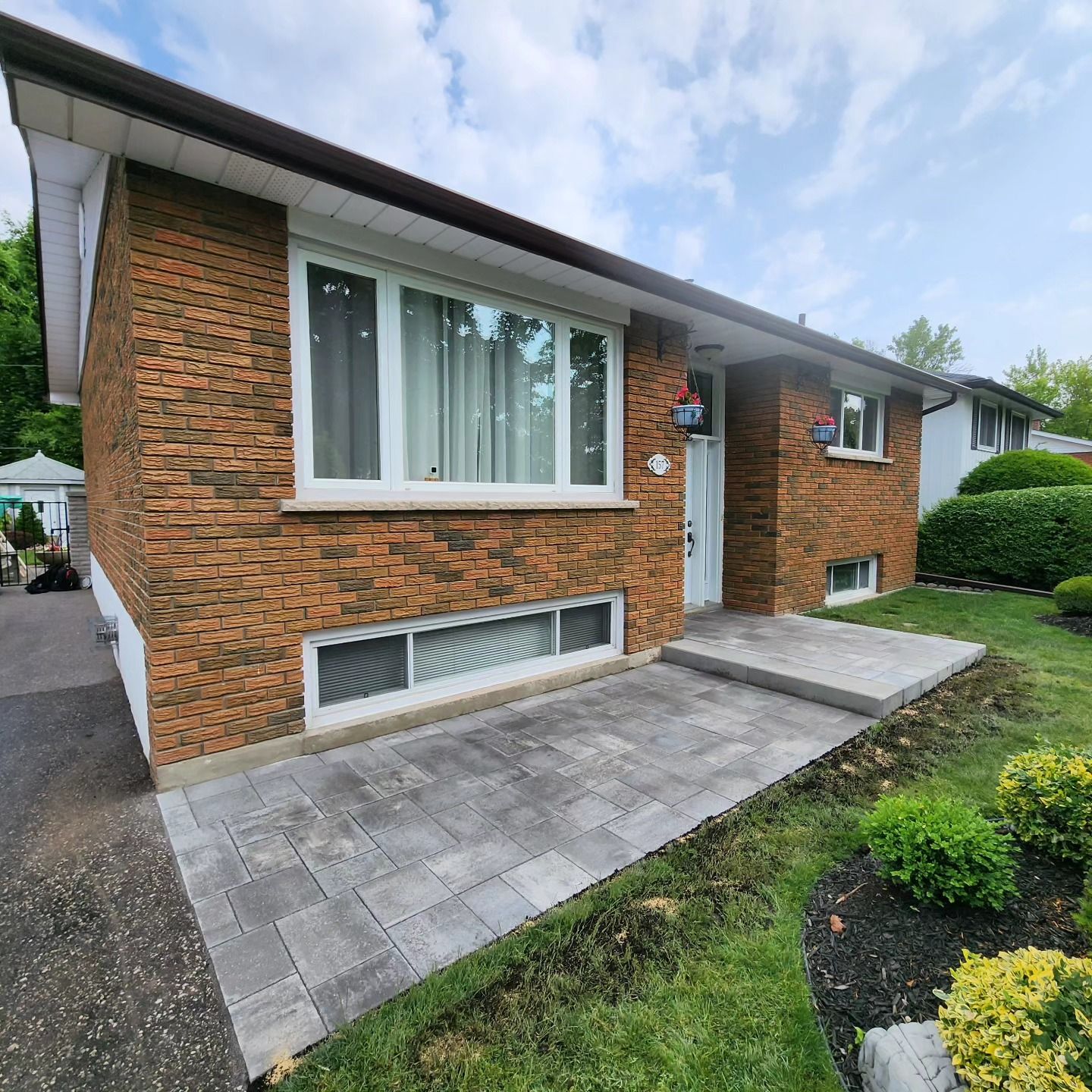 A brick house with a concrete walkway leading to it