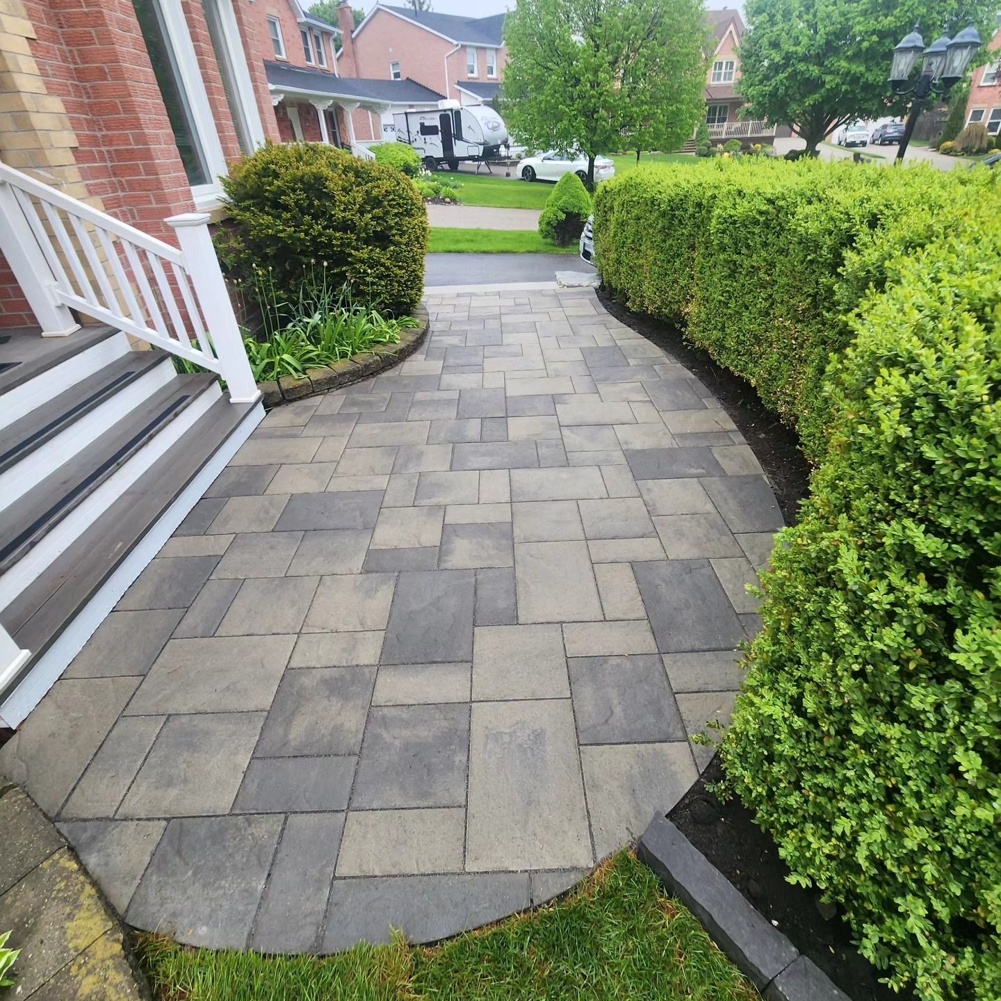 A house with a brick driveway in front of it.