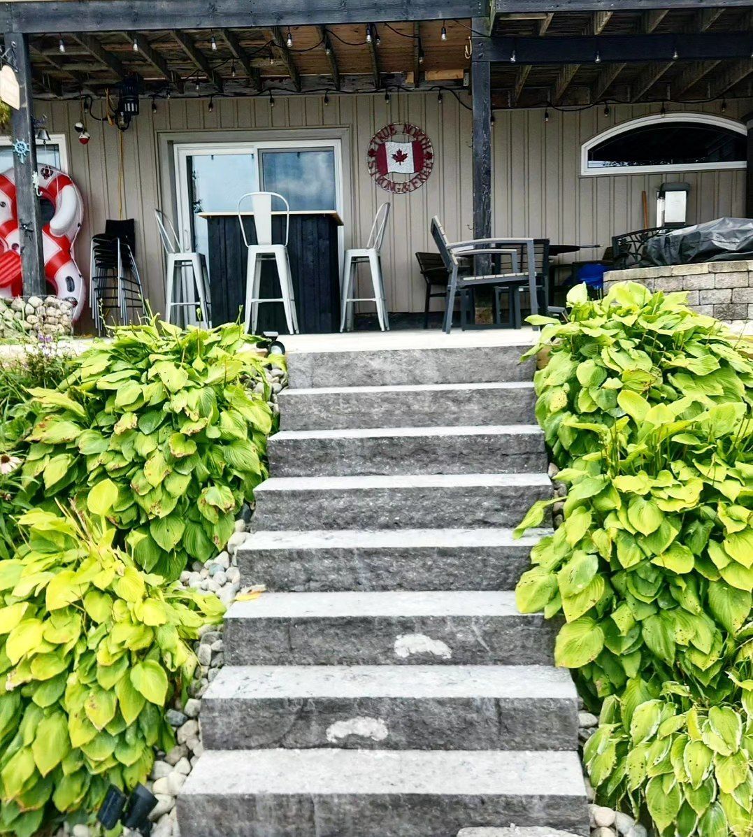A set of stairs leading up to a porch with a canadian flag on the wall.