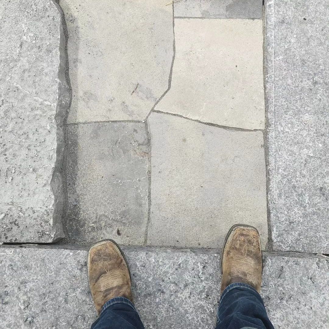 A person is standing on a cracked stone floor