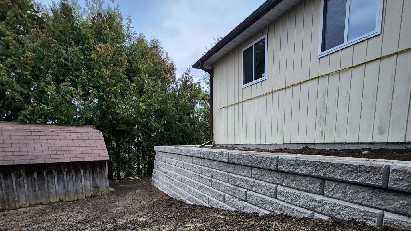 A house with a stone wall in front of it.
