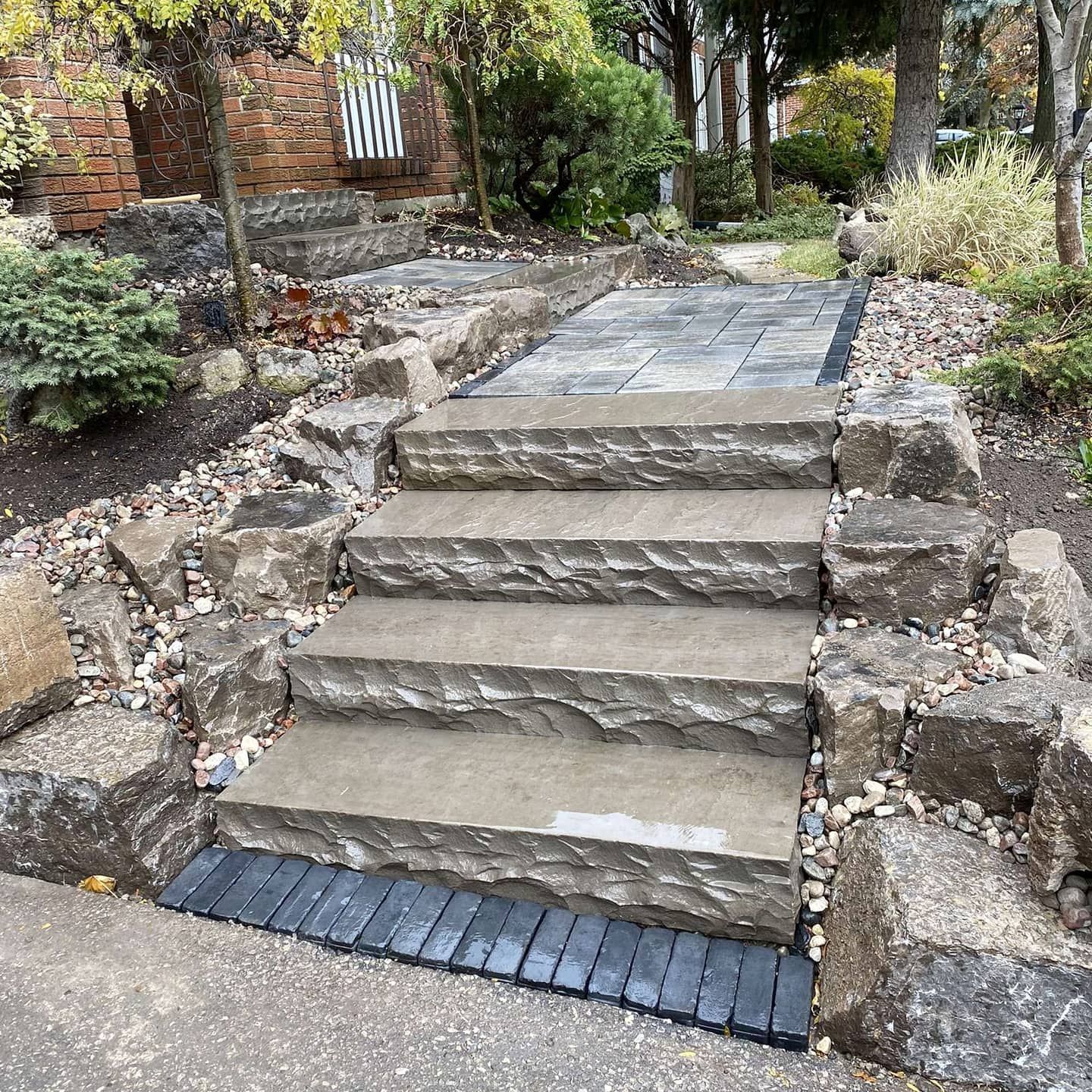 A set of stairs leading up to a house surrounded by rocks.