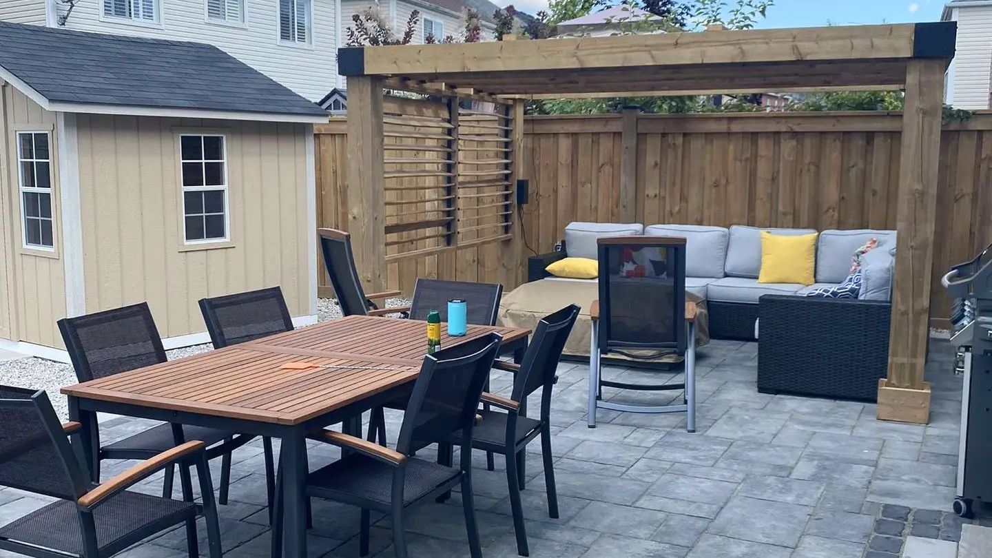 A patio with a table and chairs and an air conditioner