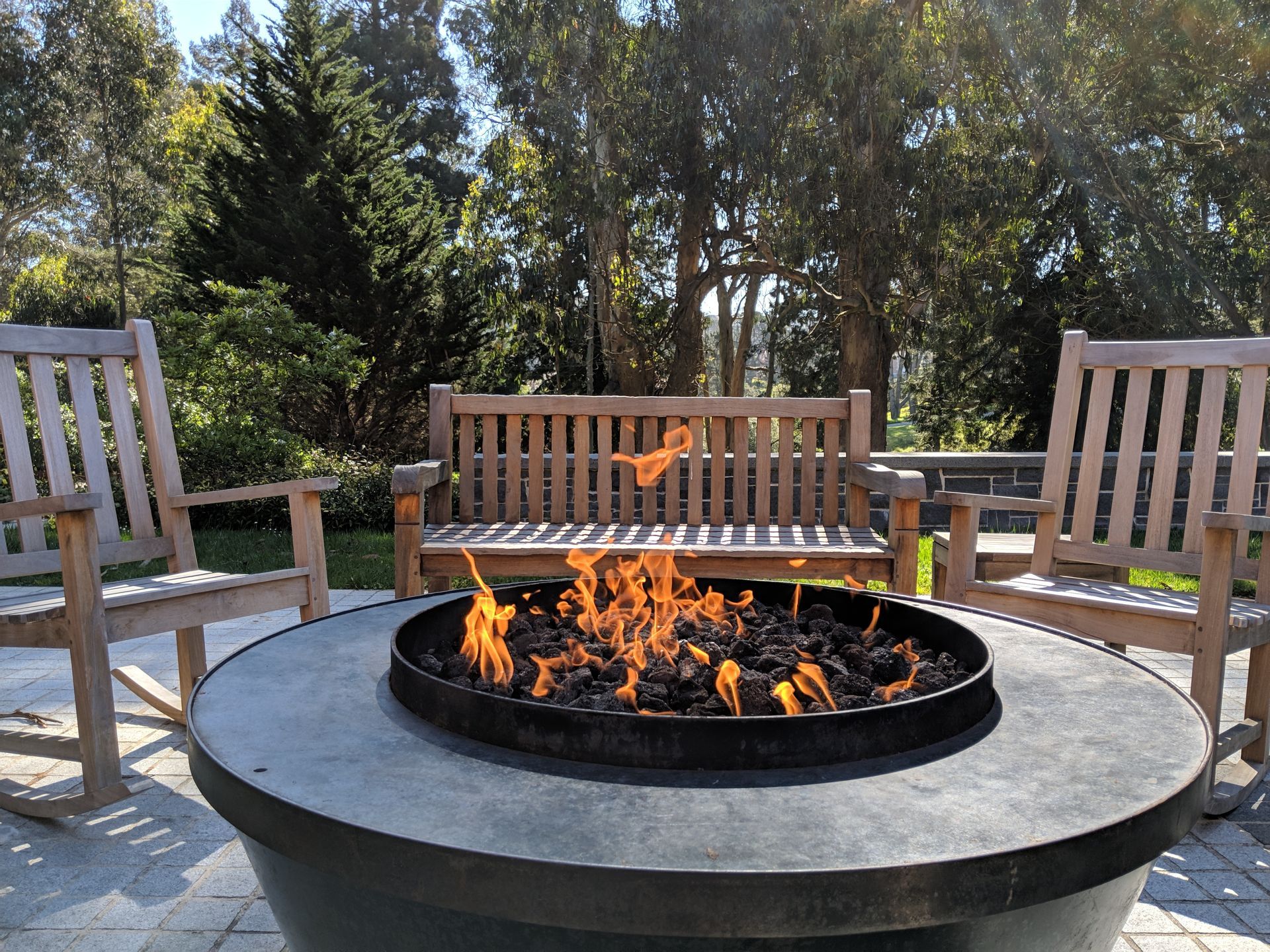 A fire pit sits in front of a wooden bench