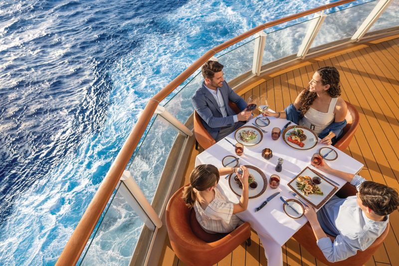 A group of people are sitting around a table on a cruise ship