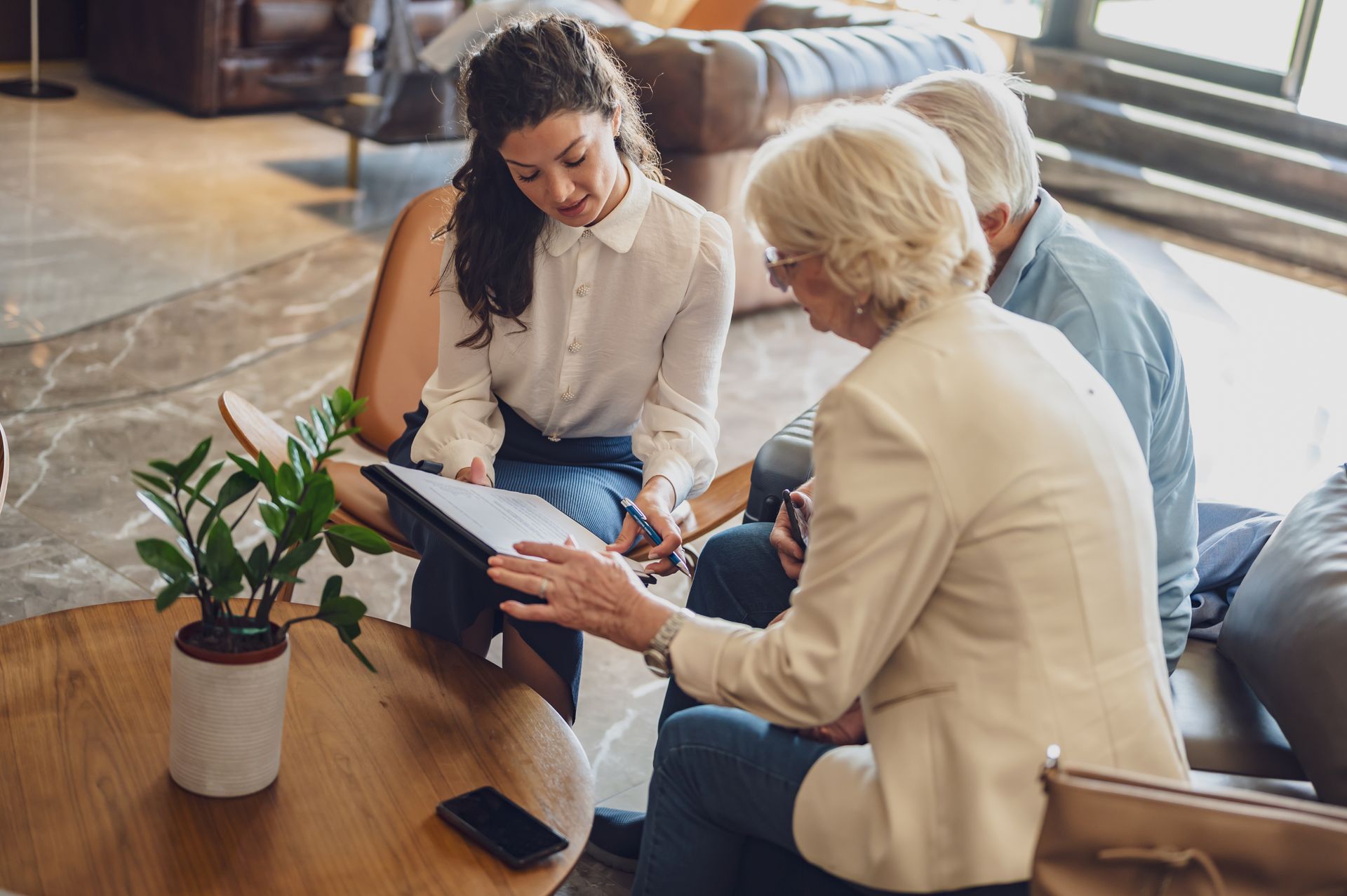 A travel advisor helps two clients with their travel planning.