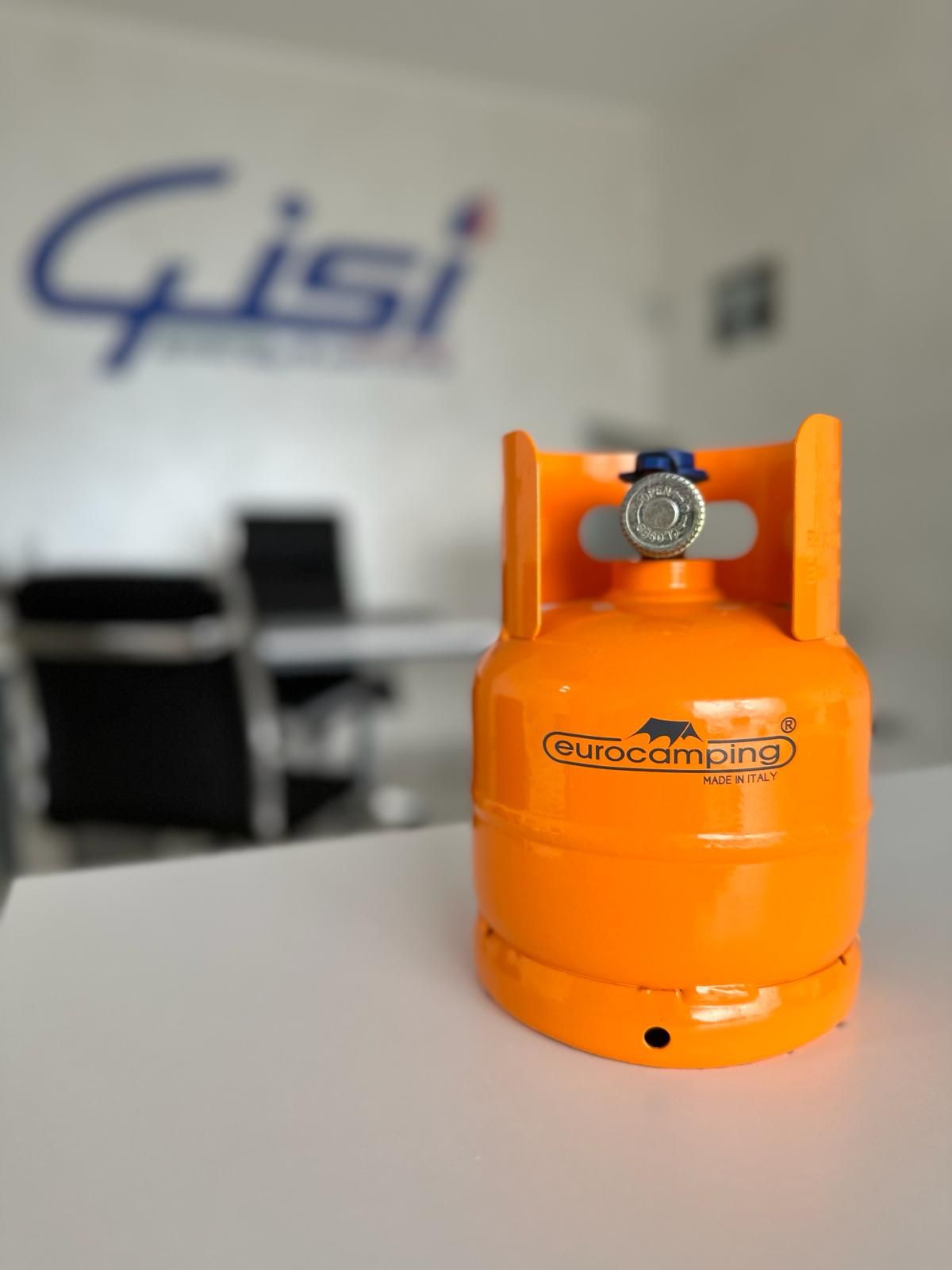 Una piccola bombola di gas arancione della Eurocamping su un tavolo bianco in un ambiente d'ufficio.
