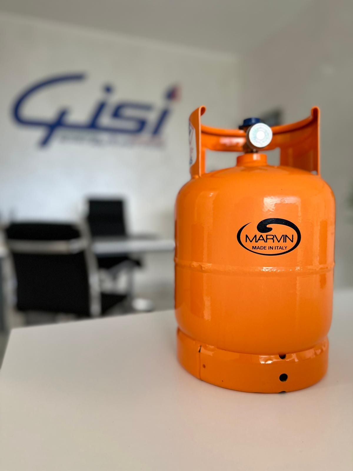 Una bombola di gas arancione della Marvin su un tavolo bianco in un ambiente d'ufficio, con il logo aziendale sfocato sullo sfondo.