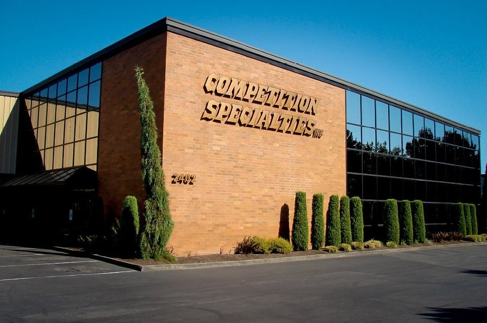A modern brick commercial building with glass windows, displaying the sign