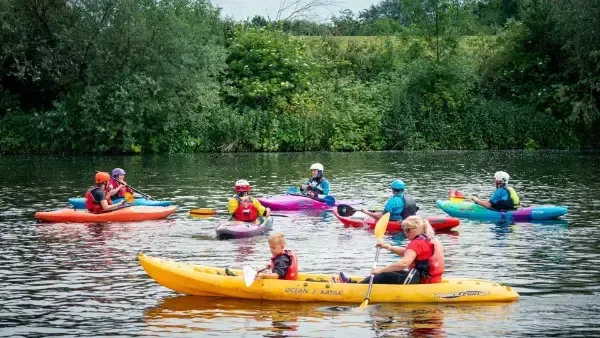 A group of people are riding kayaks on a lake.