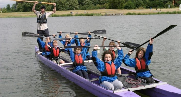 A group of people are rowing a boat on a lake.