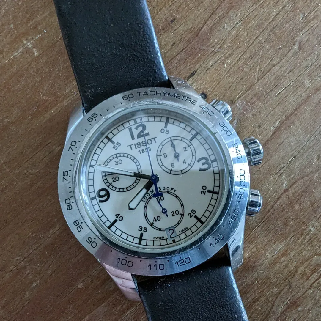 A tissot watch is sitting on a wooden table