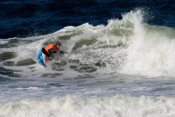 A person is riding a wave on a surfboard in the ocean.