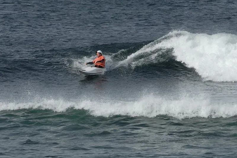 A man is riding a wave on a jet ski in the ocean.
