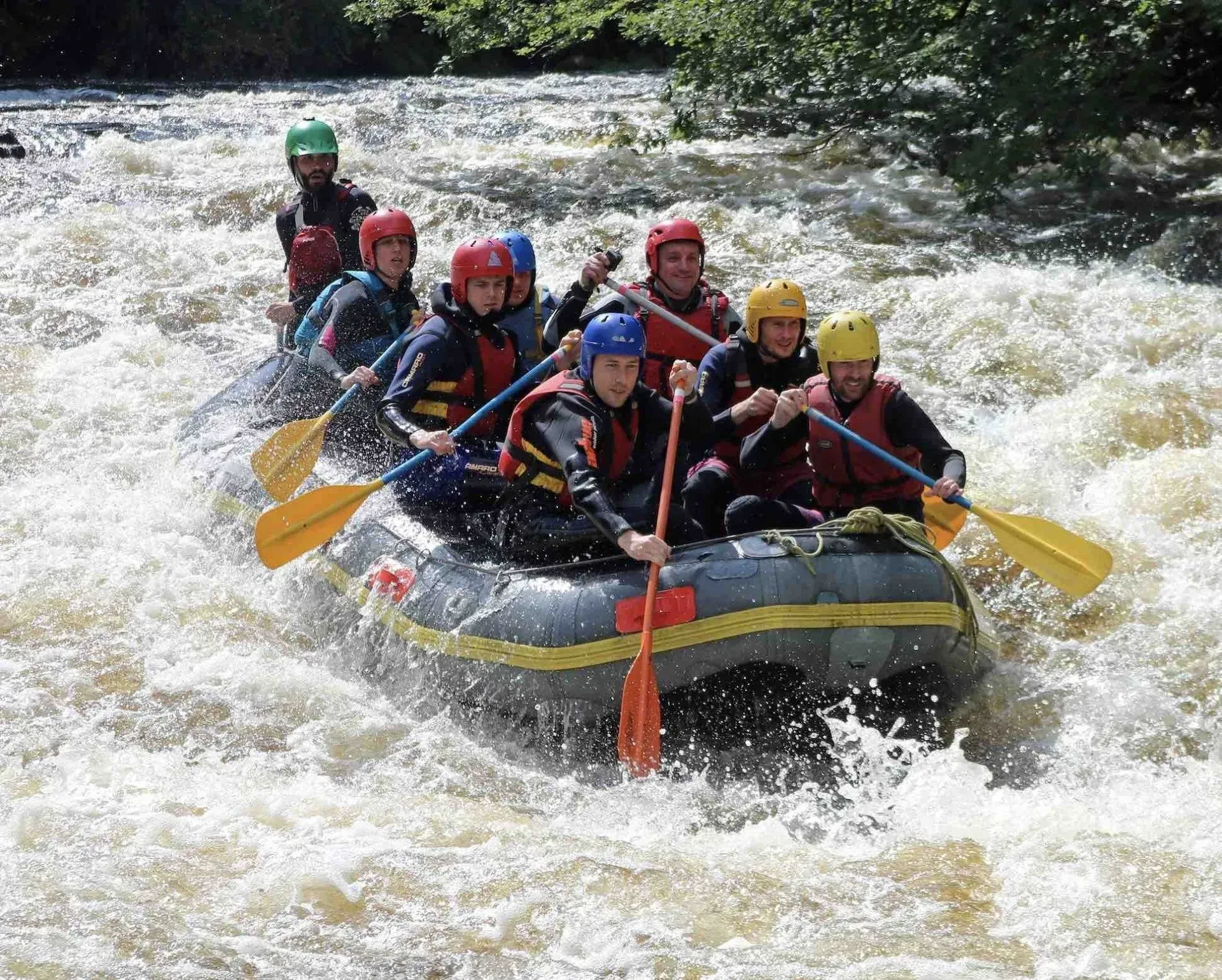 A group of people are rafting down a river in a raft.