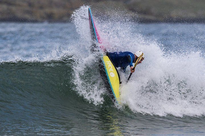 A person is riding a wave on a surfboard in the ocean.