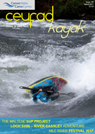 Mae person yn marchogaeth caiac i lawr afon.