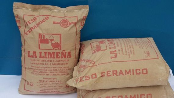 Tres sacos de cemento color beige con las etiquetas “LA LIMEÑA” y “CERÁMICO” sobre un fondo azul.