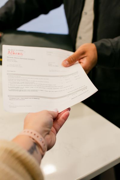 Handing over a printed document across a white table in an office setting