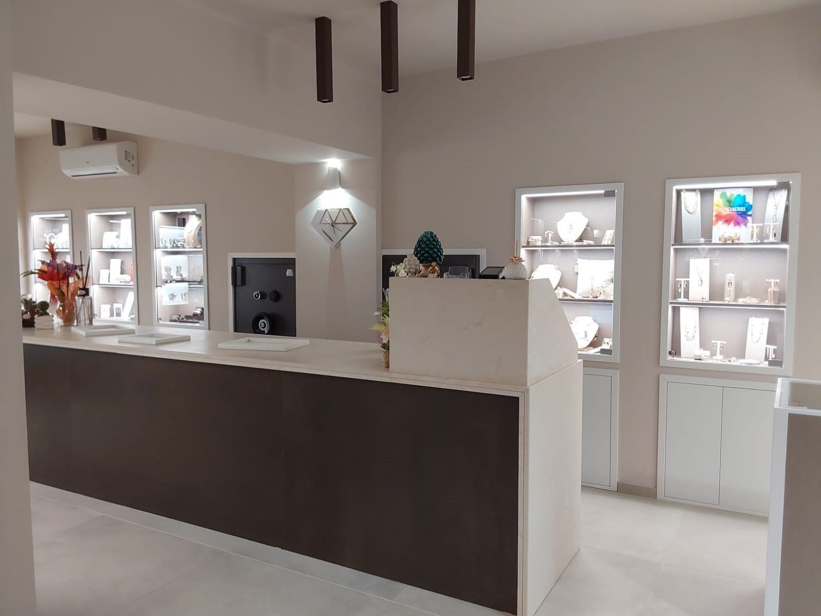 Interno di una gioielleria con vetrine, bancone e cassaforte.