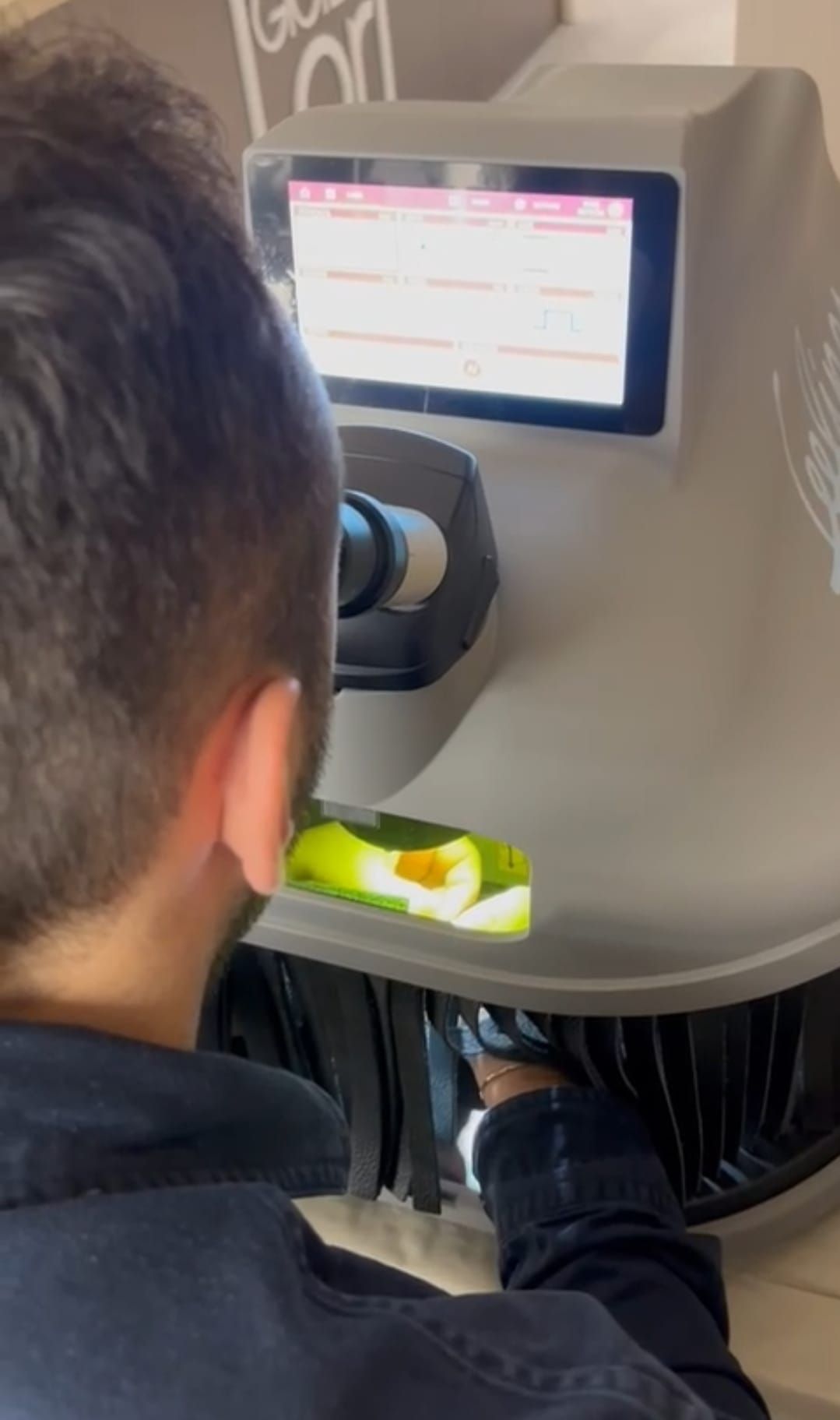 Uomo che interagisce con una macchina selezionatrice per alimenti, inserendo i prodotti. Uno schermo visualizza i dati.