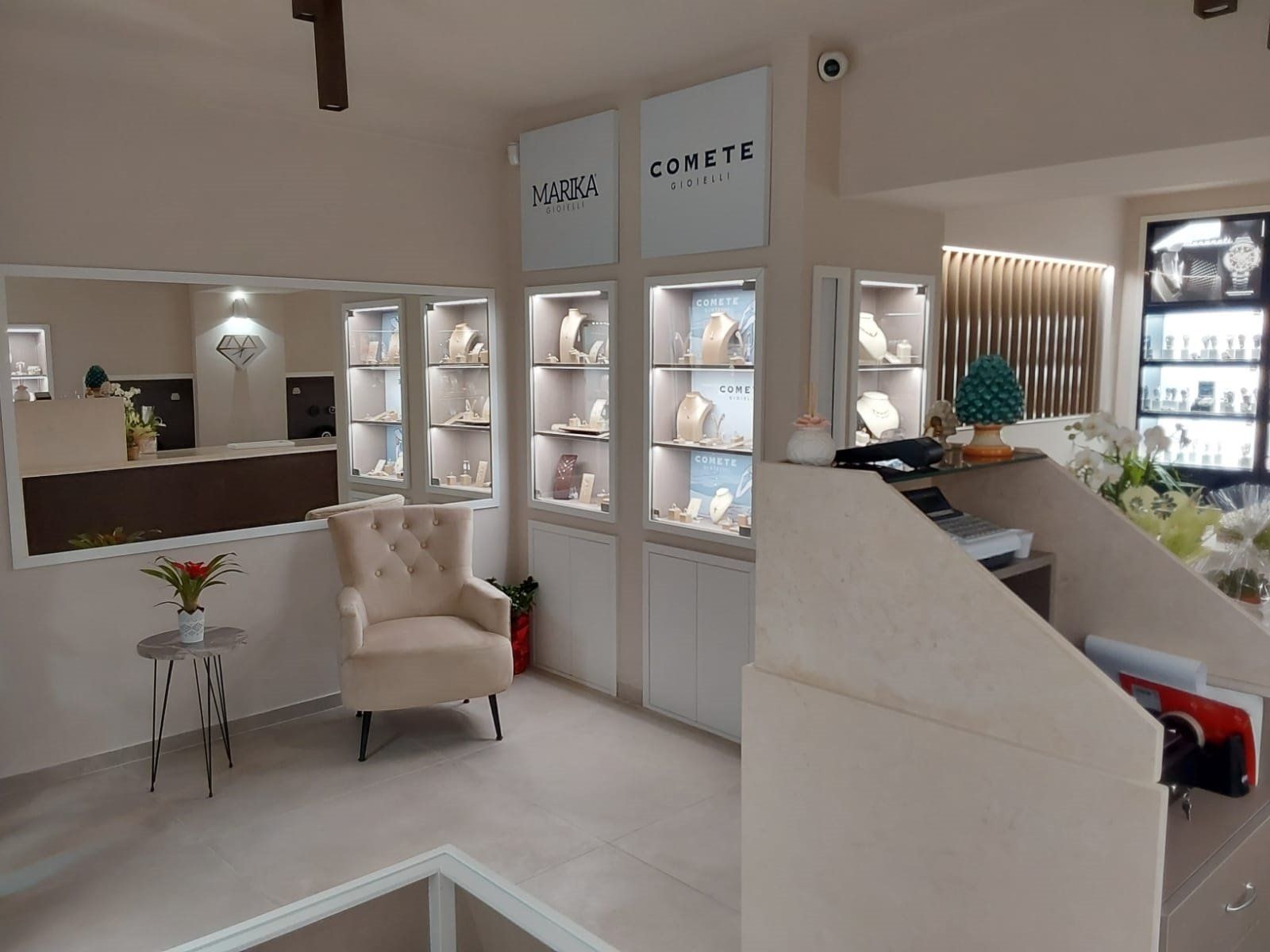 Interno di una gioielleria con vetrine, un'area salotto e una reception.