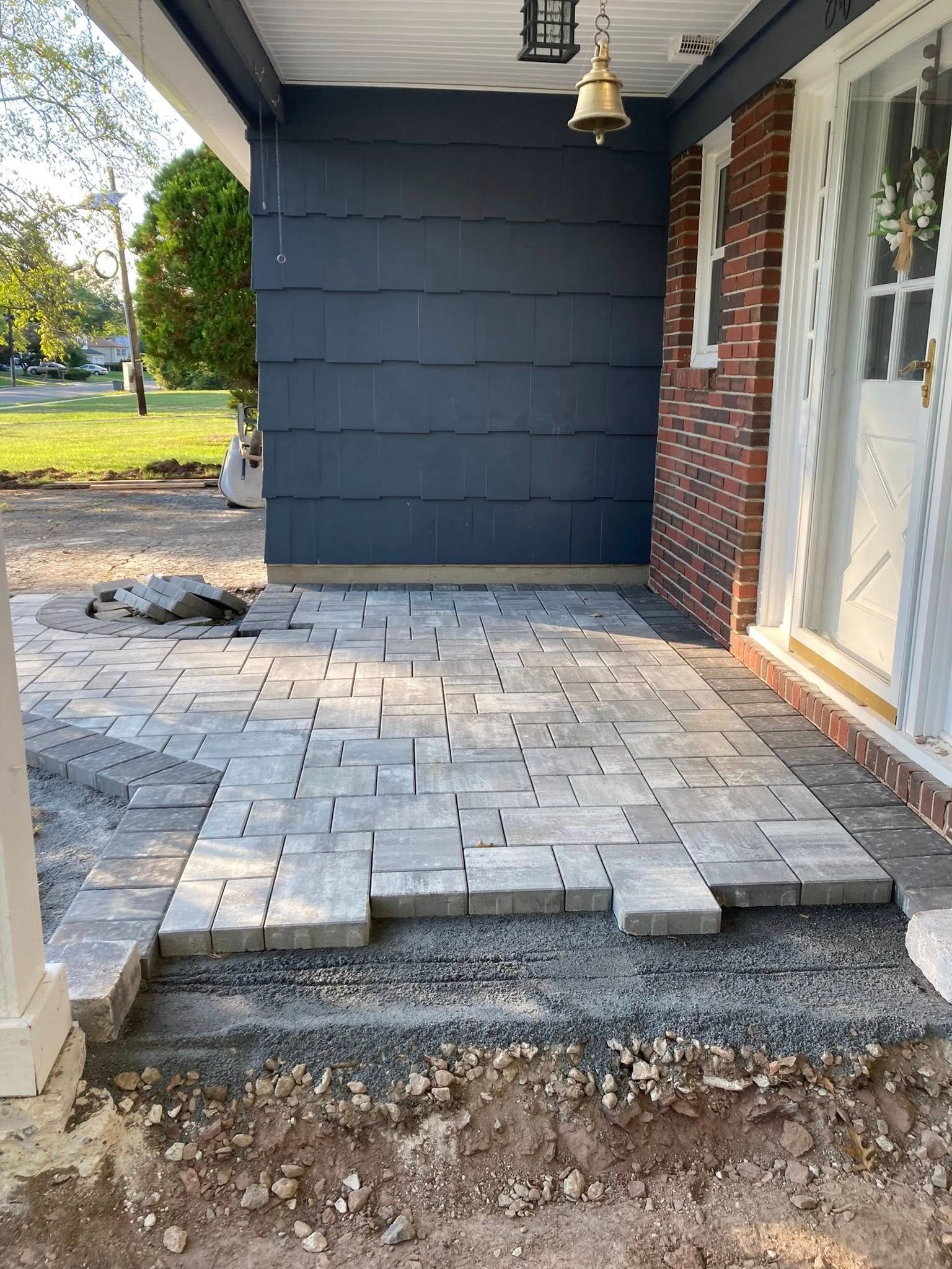 Front porch construction; paving stones being laid on gravel base.