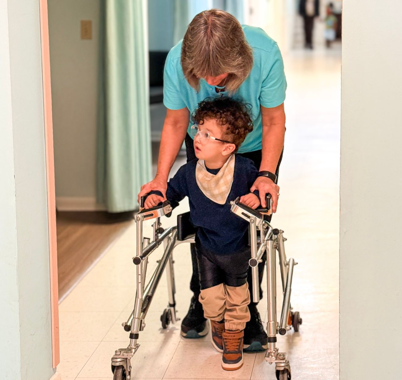 A woman in a wheelchair is sitting in front of a sign that says sunshine and sad.
