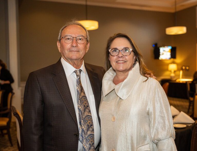 A man and a woman are posing for a picture in a room.