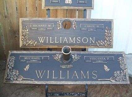 Blue memorial plaques for Williamson and Williams with floral trim and a central vase-like opening