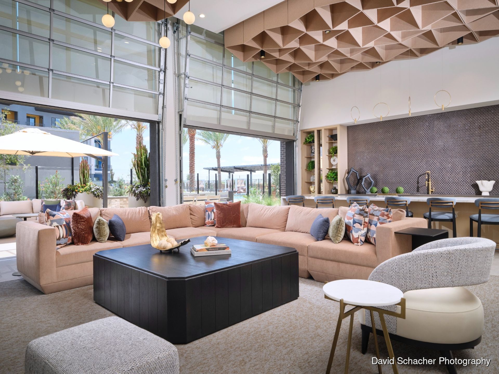 Modern living room with beige sectional, black coffee table, and floor-to-ceiling windows