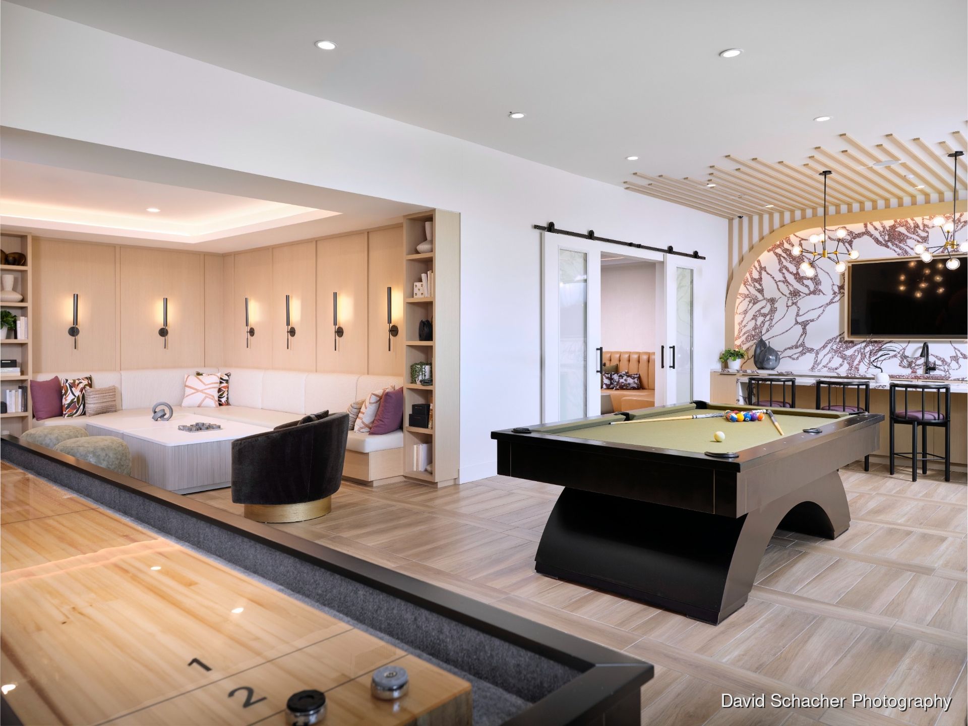 Brightly lit community room with a pool table, seating area, and wall decor.