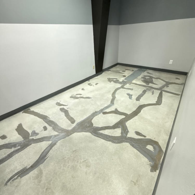 Empty carpeted room with gray patterned rug and white walls.