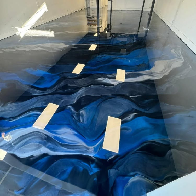 Blue-and-white marbled floor resin installation with masking tape in a room