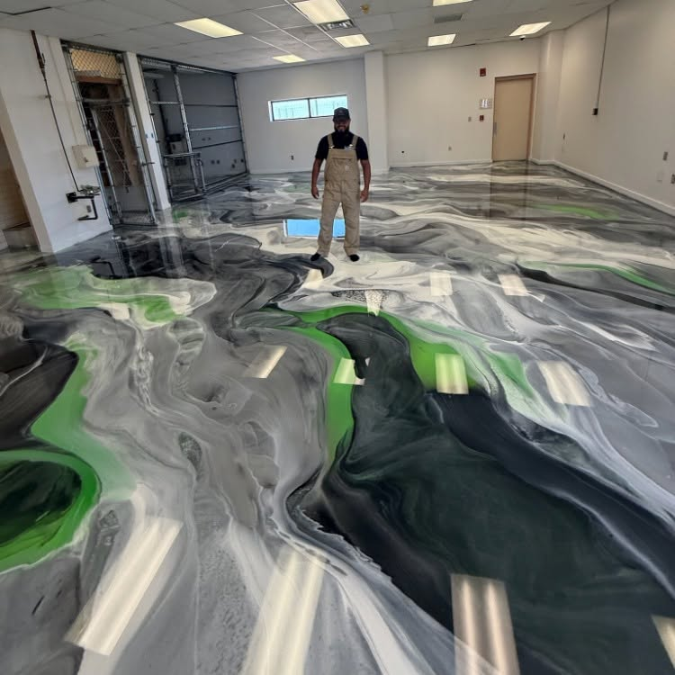 Man standing in a room with a black, white, and green marbled floor coating applied