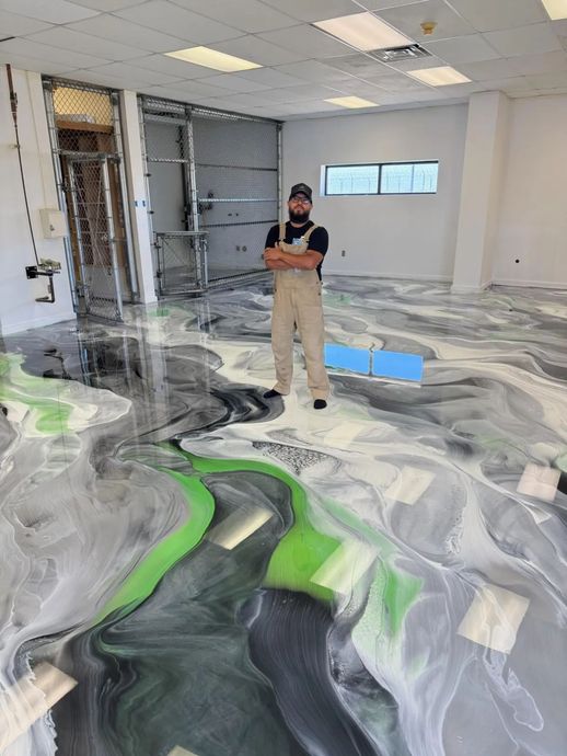 Person standing in a room with a gray, white, and neon green epoxy floor under renovation
