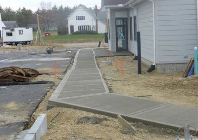 A concrete walkway is being built in front of a house.