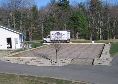 A white truck is parked in front of a building under construction.