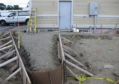 A construction site with a ladder in front of a building