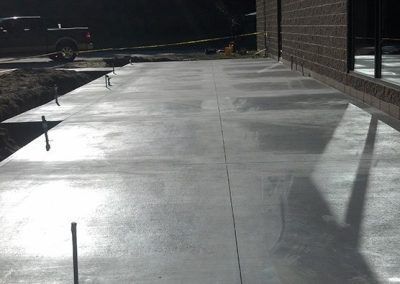 A truck is parked on the side of a concrete driveway.