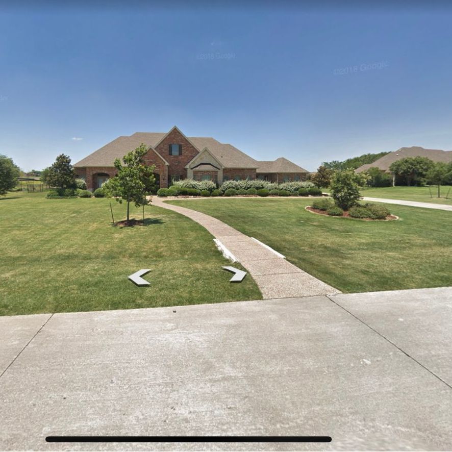 A large brick house with a walkway leading to it