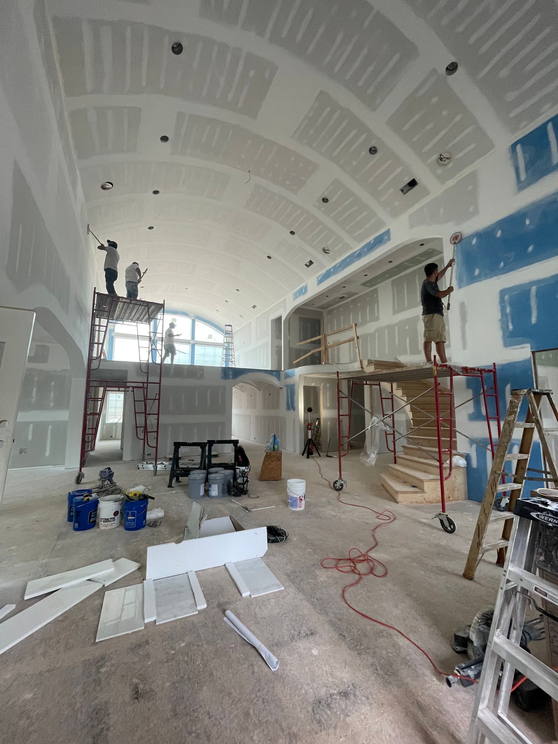 A man is painting a wall in a large room