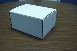 White cardboard box on a wooden table.