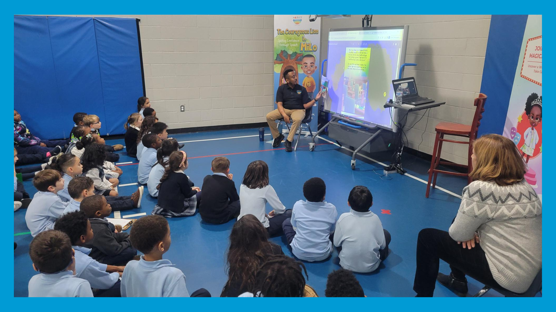 Myles reads The Courageous Lion in Milo to a group of young students seated on the floor, during an interactive classroom presentation.