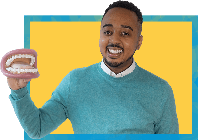 Myles nobles wearing a teal sweater while holding a speech therapy tool