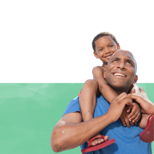 A father is holding his son on his shoulders.