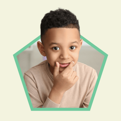 a boy with his hand on this lips smiling