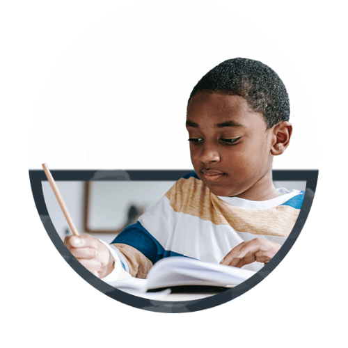 A young boy writing in a notebook