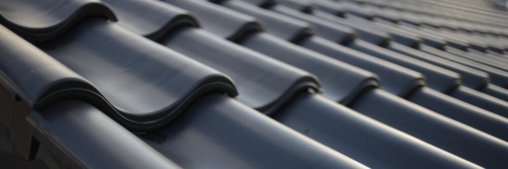 A Close up Of a Row of Black Tiles on A Roof — Roof Masters NQ in Douglas, QLD